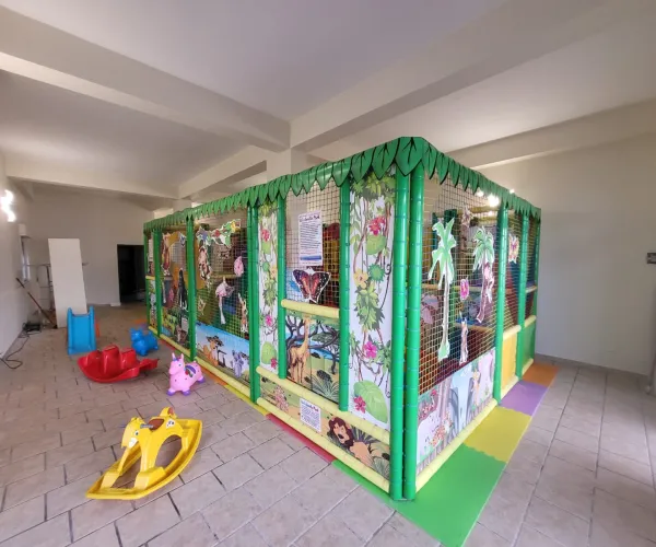 Area giochi interna con scivolo e tappeto anti-trauma per la festa di compleanno a Letojanni
